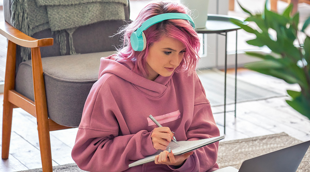 girl with pink har and pipnk jumper with aqua headphones